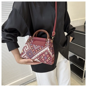 Detailed view of colorful woven handbag with ethnic geometric pattern and round wood handle