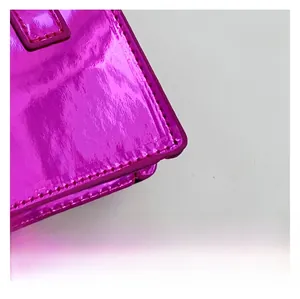 Close-up of premium metallic patent leather with precise stitching on a mini crossbody bag