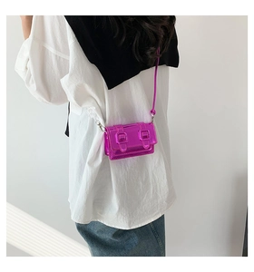 Mini metallic purple square crossbody bag with buckle detail on a model's back view