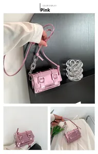 Detail of pink metallic crossbody bag featuring an acrylic chain and dual buckle flap