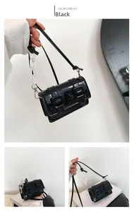 Detail of a black patent leather mini shoulder bag with acrylic chain and buckles