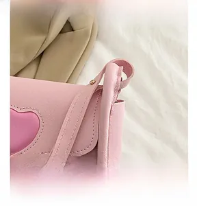 Nahaufnahme der rosa Umhängetasche aus Kunstleder mit Herz-Detail und feiner Litschitextur