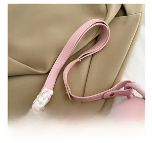 Detail eines rosa Leder-Schultergurts mit Goldschnalle und dekorativer Seidenschal-Deko