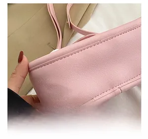 Detailansicht der präzisen Nähte und glatten Textur einer rosa Lederhandtasche