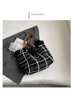 Détail du sac cabas tissé noir et blanc avec bordures à franges et anses en cuir marron