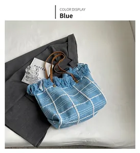 Détail du cabas tissé bleu avec bords à franges et anses en cuir marron