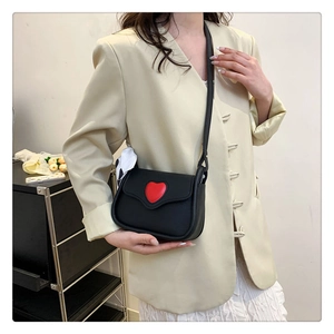 Detailansicht der schwarzen PU-Ledertasche mit rotem 3D-Herz und Polka-Dot-Seidenschal