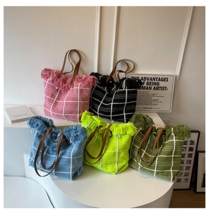 Detail of woven tote bags with tassel trim and leather handles in five fashion colors