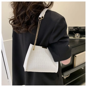 Borsa a spalla bianca con motivo a coccodrillo e catena dorata indossata da modella