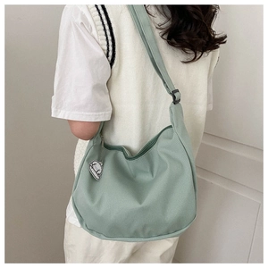 Détail du sac croissant en velours côtelé vert menthe avec pendentif nuage blanc