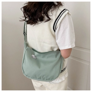 Detail of light green striped tote bag with adjustable strap and cute cartoon charm