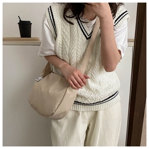 Détail du sac bandoulière en velours côtelé beige avec un petit pendentif de chien mignon