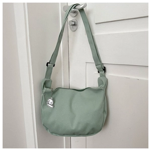 Détail du sac bandoulière en velours côtelé vert menthe avec pendentif chiot mignon