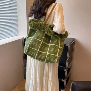 Green woven tote bag with white checkered pattern and stylish fringe detail for women