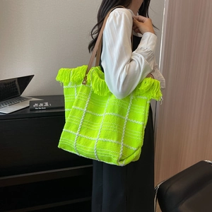 Fluorescent green knit tote bag with white checkered pattern and fringe detailing