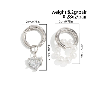 Vue détaillée des breloques asymétriques en cristal de cœur et perles sur créoles argent