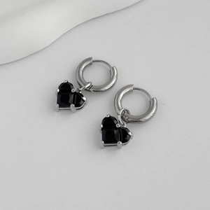 Detailed close-up of heart-shaped black gemstone earrings with silver metallic hoops