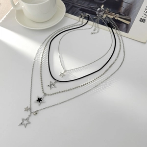 Detailed view of layered necklaces featuring silver stars and rhinestone cross pendants