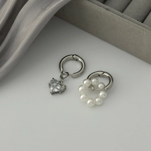 Vue détaillée de boucles d'oreilles asymétriques en argent avec perle et zircon cœur