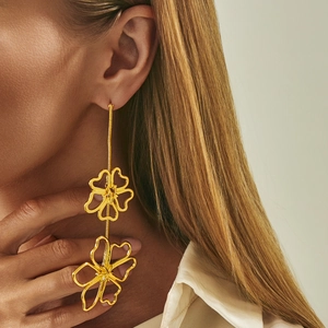 Close-up of elegant gold long tassel flower earrings worn on model for detail
