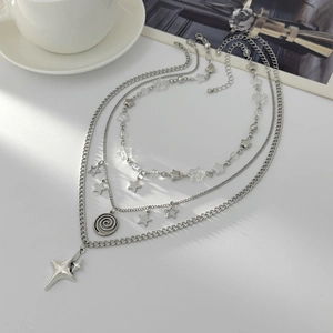 Detail of layered silver necklaces with star pendants, flat lay fashion accessories