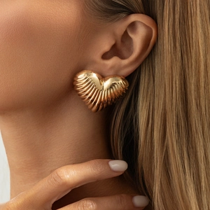 Chic oversized heart-shaped gold earrings with ribbed texture and glossy metallic finish