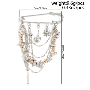 Macro view of star and heart charms on a pin brooch with chains and metallic beads