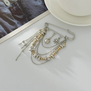 Irregular CCB bead chain brooch with metal heart and star pendants on white surface