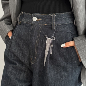Silver star tassel brooch with metal chains shown as a stylish denim pant accessory