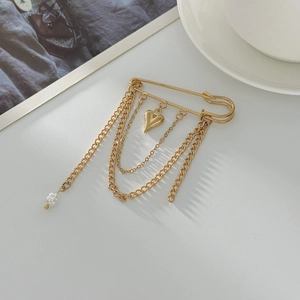 Golden safety pin brooch with heart pendant, layered chains and white faux pearl detail