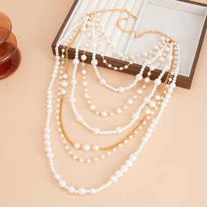 Elegant multi-layer baroque pearl necklace set with gold chains on a jewelry box