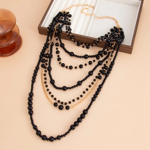 Detail of multi-layered pearl necklace with black beads and gold-tone metal chains