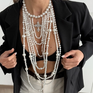 Detail van meerlaagse barokke parelketting met een fonkelende strass kruishanger