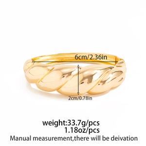 Detail view of gold twisted cuff bracelet with dimensions 6cm inner diameter and 2cm width