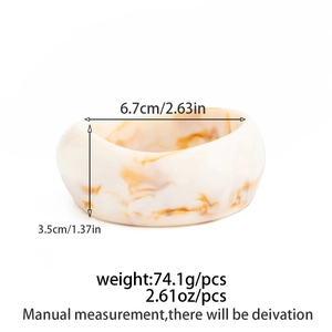 Detailed view of wide resin bangle featuring amber marble texture and size dimensions