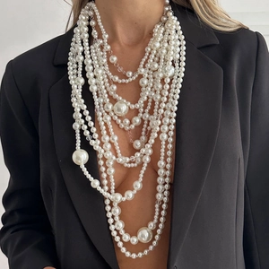 Elegant multi-layer faux pearl necklace with varied bead sizes on a fashion model
