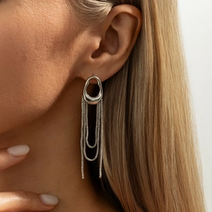 Close-up of elegant silver tassel ear cuff featuring irregular hollow oval and long chains