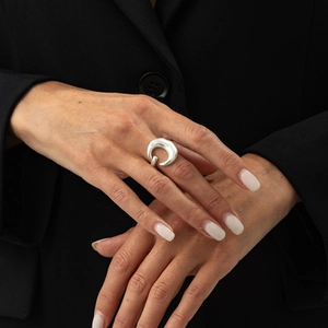 Macro detail of silver wide ring with irregular curved shape and matte satin finish