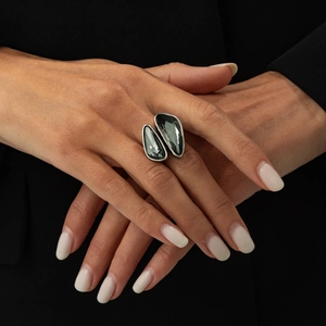 Close-up of a silver double-stone ring with irregular dark grey acrylic crystals on a hand