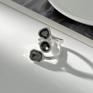 Detail of silver alloy wrap ring featuring heart, round and square black gems