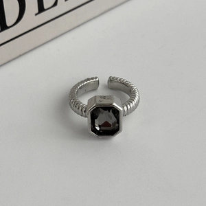 Detailed close-up of a silver twist ring featuring a dark grey faceted acrylic stone