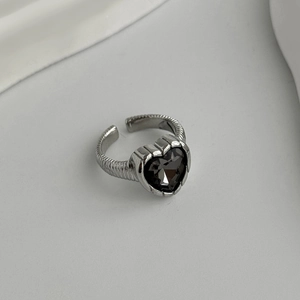 Detail view of heart-shaped black gemstone ring with silver spiral textured band