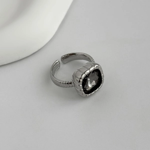 Detail view of silver adjustable ring featuring a square dark acrylic gemstone inlay