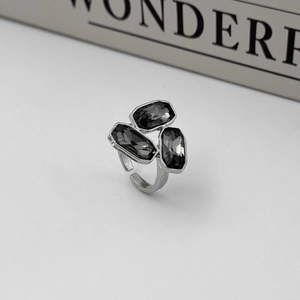 Detail view of adjustable silver ring with three rectangular grey gemstones in minimalist style