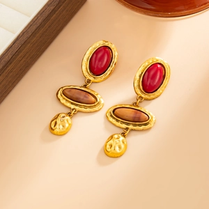Nahaufnahme der Vintage-Goldohrringe mit roten Steinen und brauner Achat-Textur