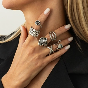 Set of six silver rings with geometric gray gems and textured band styles on a hand