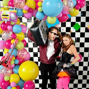 80s retro party decor detail with music radio props, checkered backdrop, and vibrant balloons