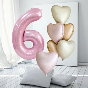 Detailed view of giant pink number 6 balloon with pastel heart-shaped foil balloons
