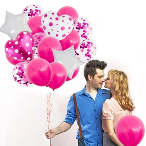 Couple holding a bunch of pink heart balloons with confetti for Valentines decoration