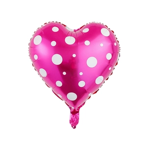 Detail of pink heart-shaped foil balloon with white polka dots for party decoration